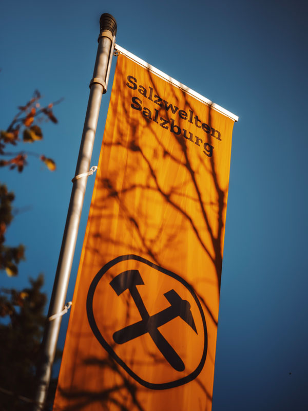 Orangefarbene Fahne der Salzwelten Hallein mit Logo