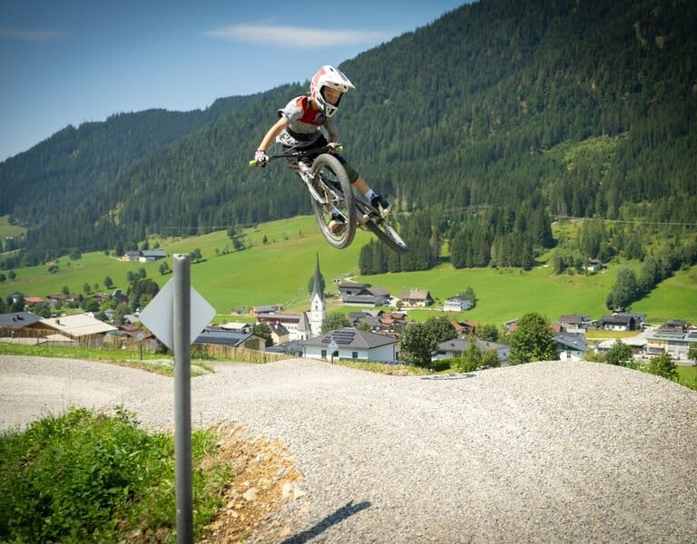 Ein Kind springt mit dem Fahrrad auf der Jumpline im Bikepark Martinerhof