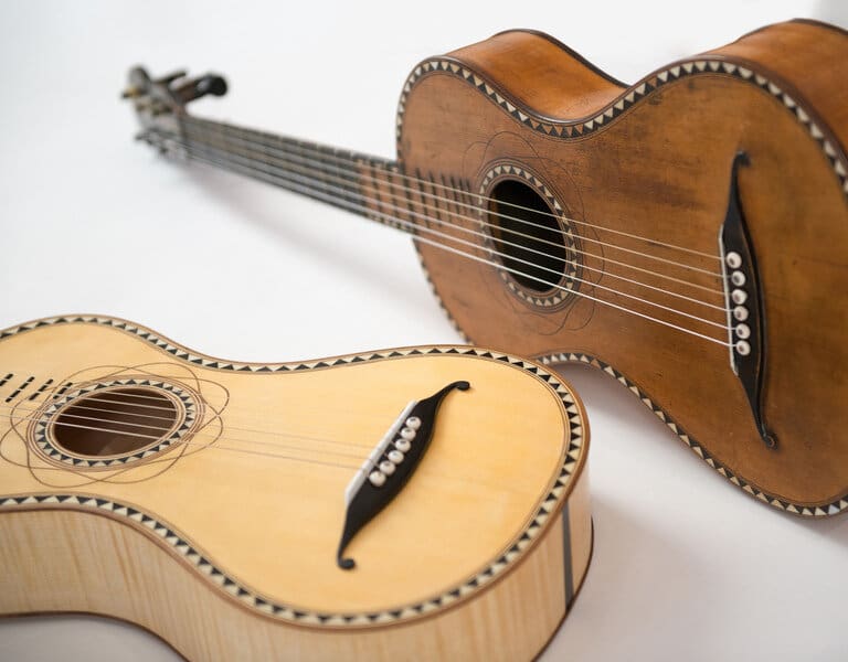 Das Bild zeigt die originale Gitarre von Joseph Mohr samt einer Replica